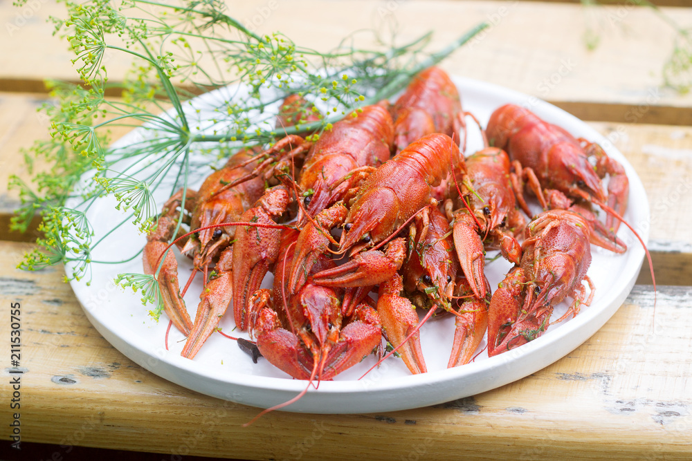 Fresh crayfish boiled with spices and dill served on a round dish. Fresh crayfish boiled with spices and dill served on a round dish.