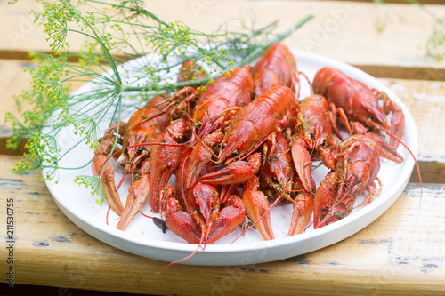 Fresh crayfish boiled with spices and dill served on a round dish.