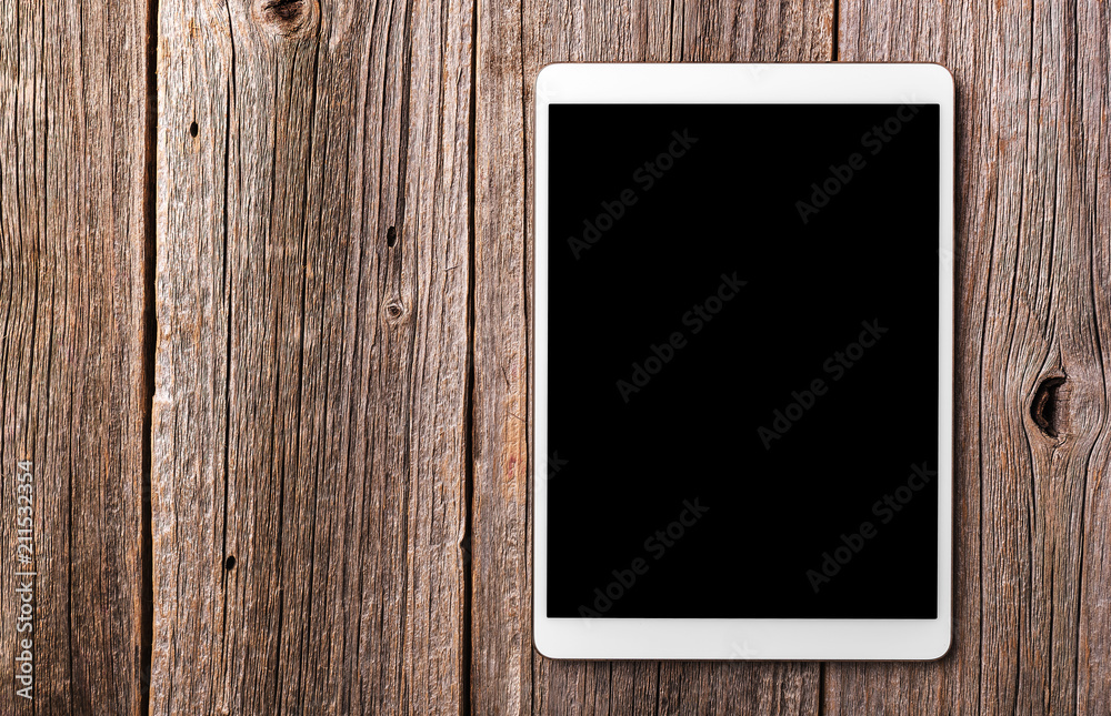 White tablet pc on old wood table background. White tablet pc on old wood table background.