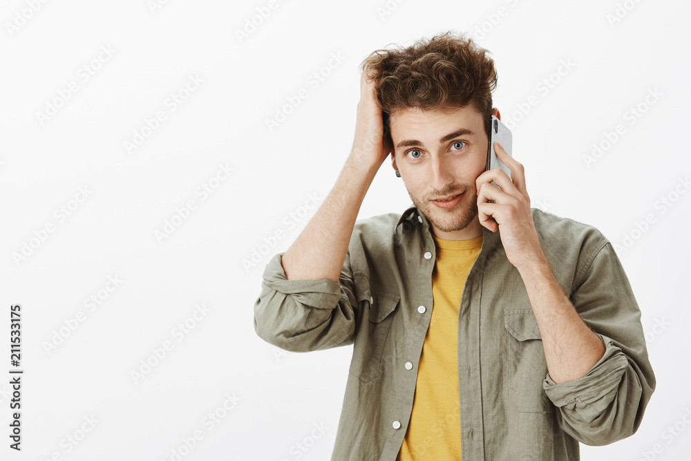 Waist-up shot of cute friendly-looking mature male coworker with blue eyes and bristle, talking on smartphone, scratching hair while gazing at camera with cute smile, thinking how to answear Waist-up shot of cute friendly-looking mature male coworker with blue eyes and bristle, talking on smartphone, scratching hair while gazing at camera with cute smile, thinking how to answear