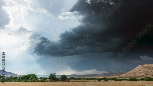 Large, powerful thunderclouds moving rapidly across Tornado Alley over barren, flat terrain forms into the beginning of a mesocyclone supercell.
 photo