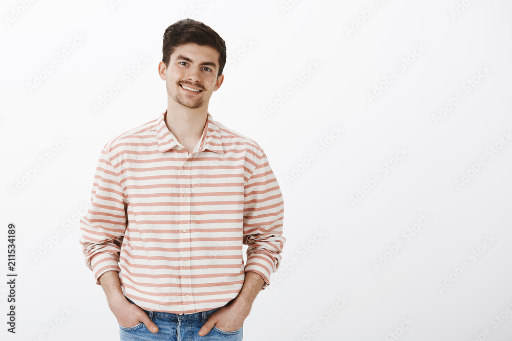 Pleasant friendly boyfriend meeting with parent. Portrait of good-looking confident man with moustache, holding hands in pockets and smiling broadly while talking with friends casually in bar Pleasant friendly boyfriend meeting with parent. Portrait of good-looking confident man with moustache, holding hands in pockets and smiling broadly while talking with friends casually in bar