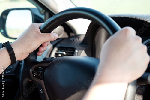 Hands of man on a steering wheel of a car. Man driving a car.