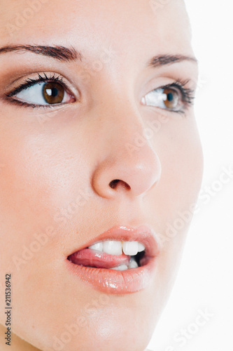 Young caucasian greedy brunette poses for a beauty session in studio with white background