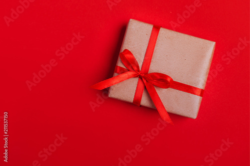 Present box with red bow on colorful background