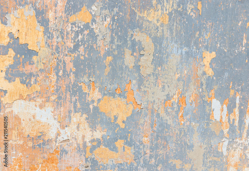 closeup of old wall with yellow and blue paint peeling off
