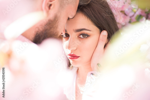 He is absolutely mine. Sensual woman enjoy intimacy with man. Couple in love hug among blossoming trees. Skincare and freshness. Desire and romance. Spring is season for love
