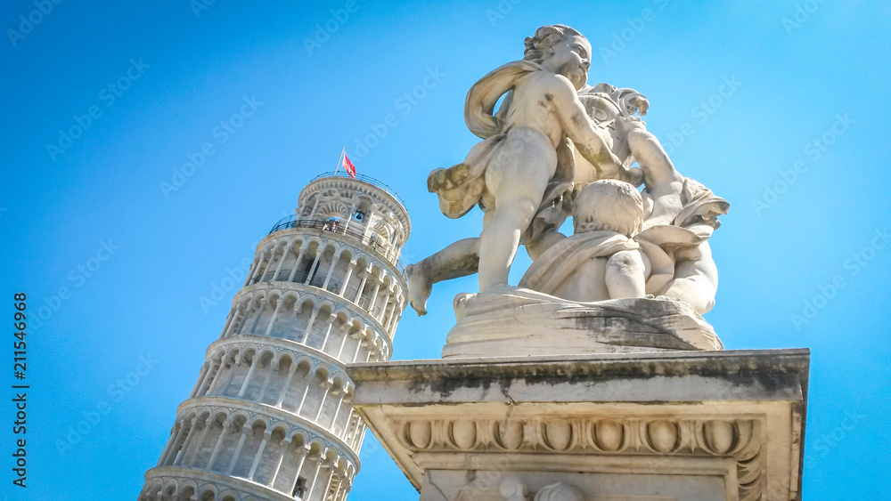 Leaning Tower of Pisa and statue of cherubs winged angels supporting heel of tower, Pisa, Tuscany, Italy.