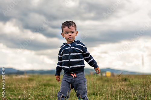 Toddler outside standing and looking away © bogdanvija