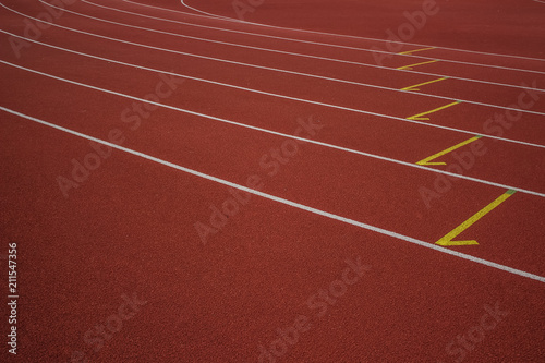empty red running track road background texture concept with white marking lanes nobody and space for copy or text 