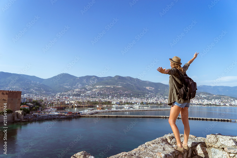 happy traveling woman, standing and enjoy the view, hands lift to the sky, travel concept, mountains sea and city on background. happy traveling woman, standing and enjoy the view, hands lift to the sky, travel concept, mountains sea and city on background.
