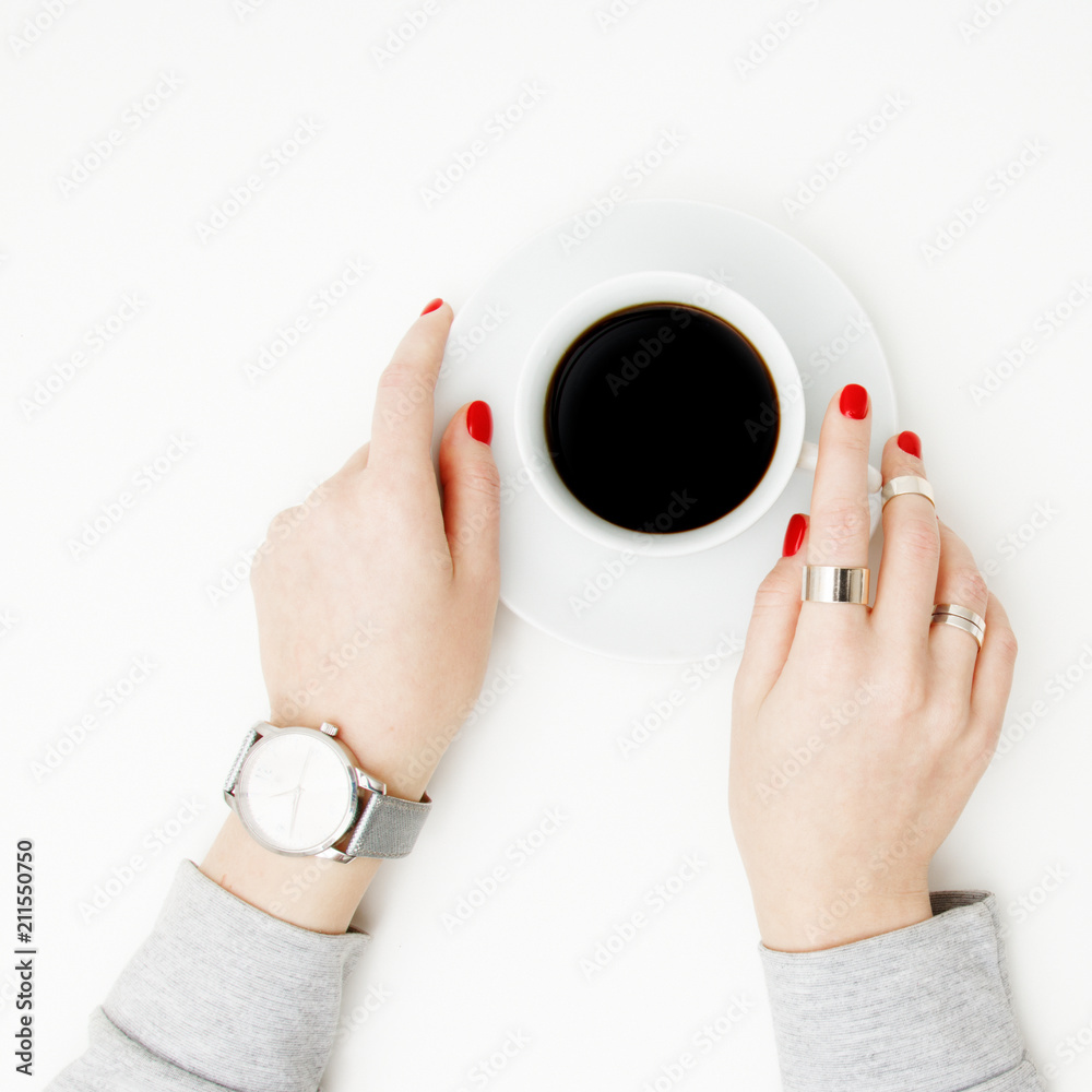 Obraz premium Flat lay. Top view. Minimal style. Minimalist Fashion and beauty photography. Morning mood. A girl in a sweater manicure holds a white cup of coffee on a white table background. Watches and jewelry