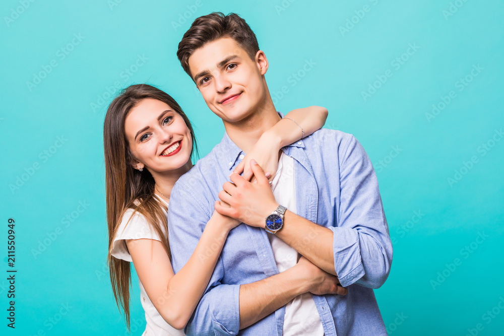 Young hug couple smiling on a blue background Young hug couple smiling on a blue background