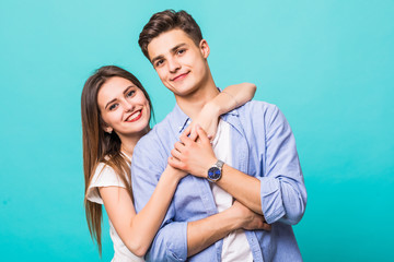 Young hug couple smiling on a blue background