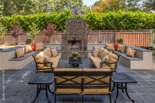 Comfortable & Inviting Outdoor Living Room and Fireplace with multiple seating areas, benches and tables