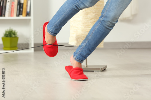 Photos Woman stumbling with an electrical cord at home
