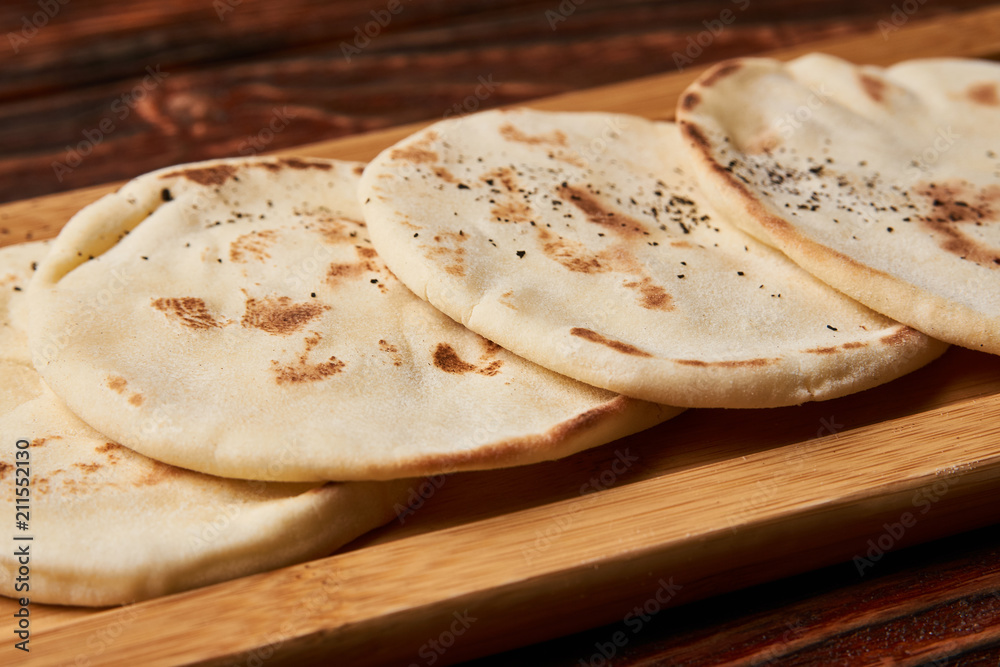 Pita bread on wooden cutting board. Corn tortilla bread on rustic wooden table Pita bread on wooden cutting board. Corn tortilla bread on rustic wooden table