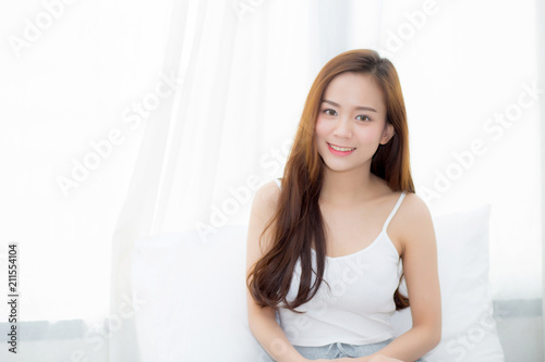 Free Download Portrait beautiful young asian woman sitting and smile the window at bedroom while wake up with sunrise at morning, lifestyle and relax concept. - GFXLoad