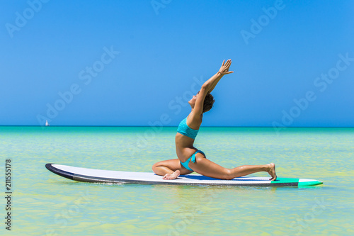 Woman practicing yoga on a paddle board 