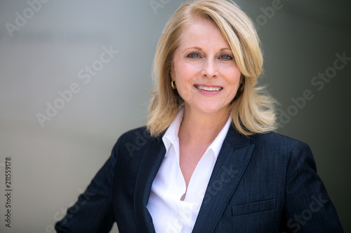 Smiling head shot of a mature older female business leader, warm, friendly, likable, executive professional