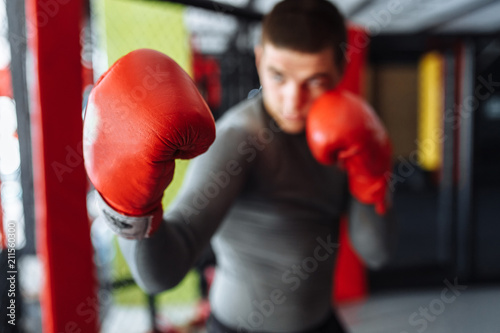 Boxing glove close-up, male boxer engaged in training in the gym, in a cage for a fight without rules © Shopping King Louie