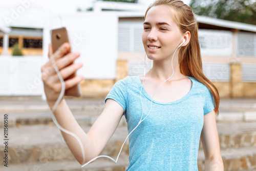Girl athlete with a phone in her hands, running listening to music, morning training Free Download Girl athlete with a phone in her hands, running listening to music, morning training - GFXLoad
