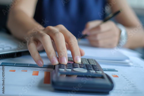 Businesswoman using calculator for analysis maketing plan, Manager calculate financial report and graph chart. Business, Finance and Accounting concepts