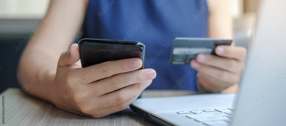 Businesswoman holding credit card and using smartphone for online shopping while making orders via the Internet. business, technology, ecommerce and online payment concept
