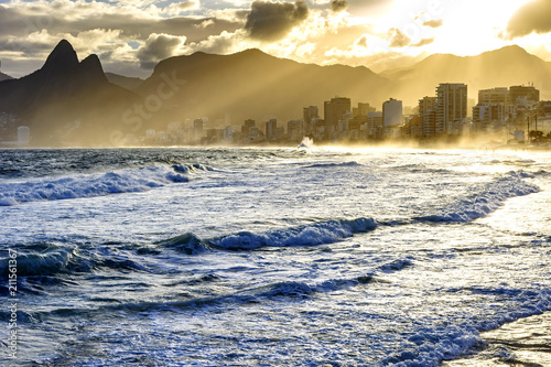 Summer sunset with cloudy sky with Two Brothers hill and Vidigal slum view from Ipanema beach at Rio de Janeiro photo