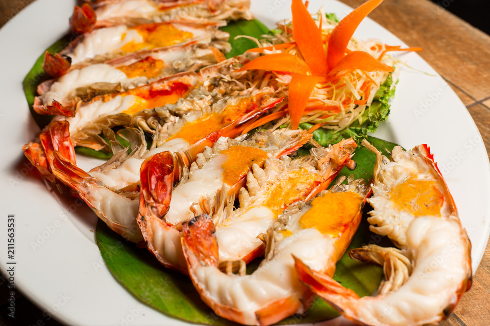 Grilled shrimp with Shrimp Paste in white dish showing the delicious Shrimp Paste inside its shell on wood table. Thai seafood. Grilled shrimp with Shrimp Paste in white dish showing the delicious Shrimp Paste inside its shell on wood table. Thai seafood.