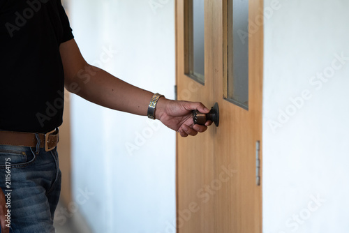 Close up of hand  holding door knob to open the door.