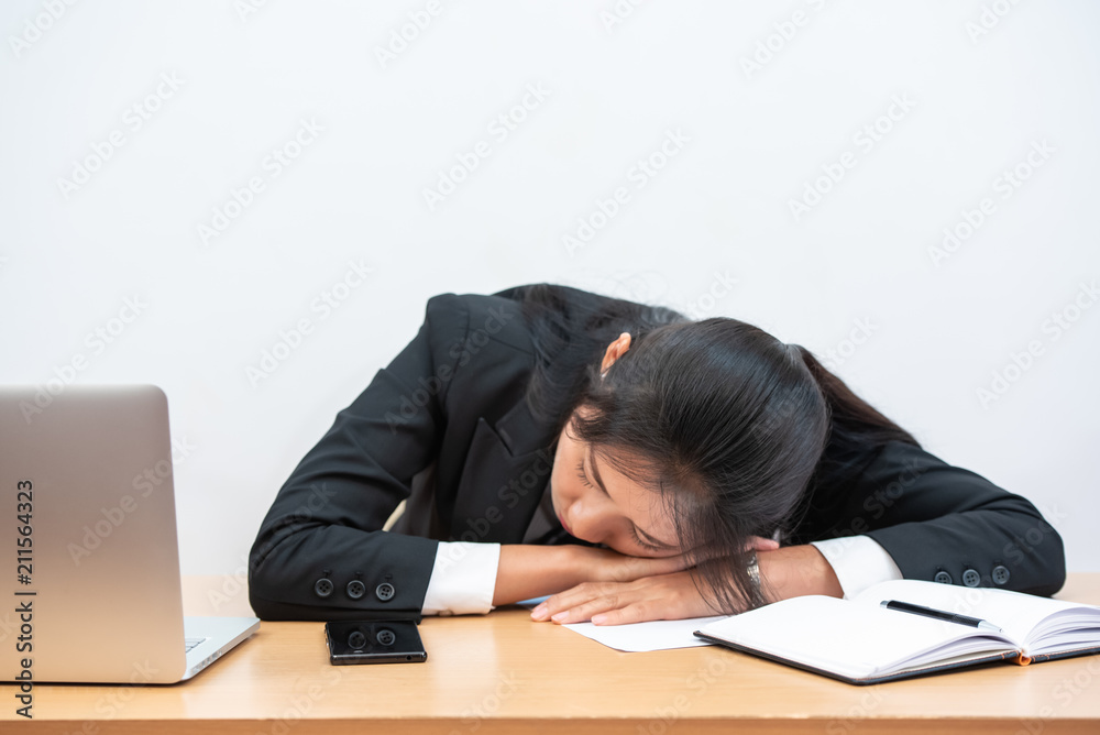 Overworked and tired businesswoman sleeping over a desk at work in her office. Overworked and tired businesswoman sleeping over a desk at work in her office.