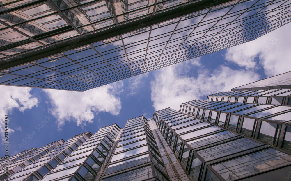 reflection of clouds in glass walls of skyscrapers in the big city and the blue sky with white clouds reflection of clouds in glass walls of skyscrapers in the big city and the blue sky with white clouds