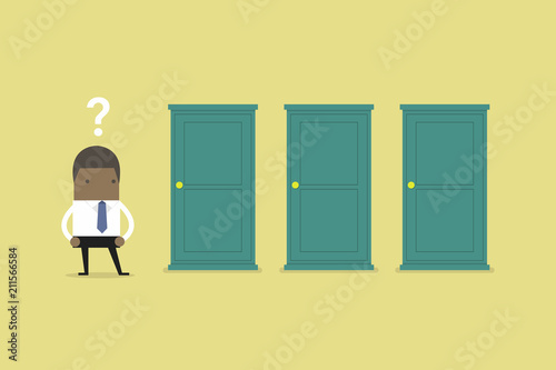 African businessman standing beside three doors, unable to make the right decision concept with question marks above his head.