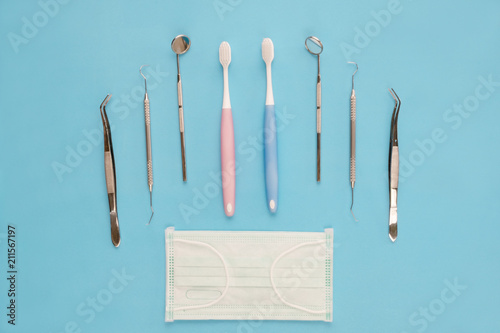 Dental tools use for dentist on the blue background, flat lay, top vipw. photo