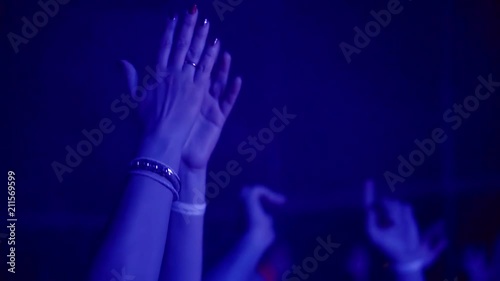 people in audience on a gig are applauding, close-up of hands of joyful woman, cheering rhythmically photo