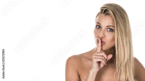 Young woman with a finger near her lips. Studio shot. Isolated on white background.