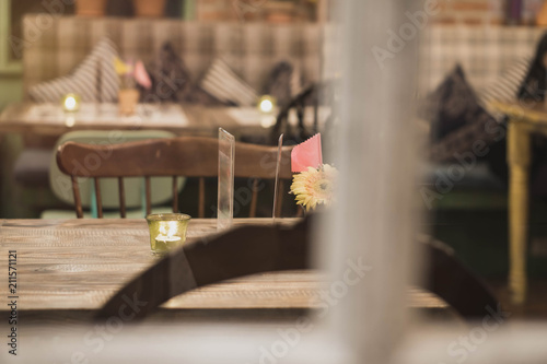 candle light on the wood desk with nice Interior of restaurant background.