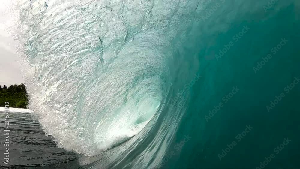 Slow motion point of view looking into tropical green surfing wave breaking over reef
