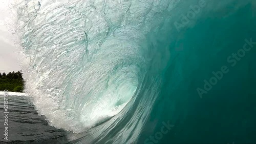Slow motion point of view looking into tropical green surfing wave breaking over reef
