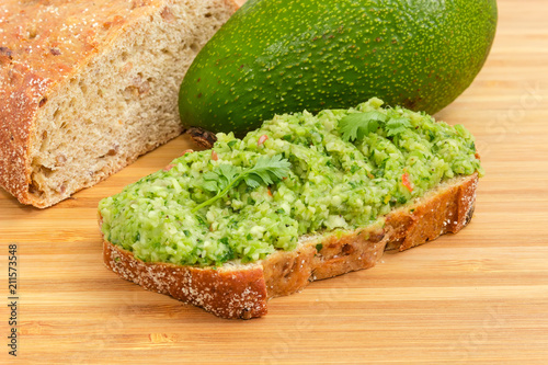 Open sandwich with guacamole against of avocado and brown bread