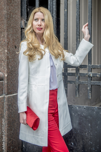 Fashionable young blonde in a spring fashionable suit and with a shopping bag in the center of Moscow
