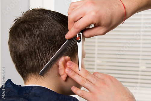 Foto The hairdresser holds a comb and scissors in her hand and makes a hairstyle for