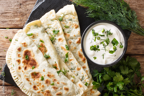Typical Turkish meal Gozleme with herb and cheese on slate board. horizontal top view
