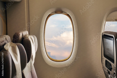 Close-up of an airplane seat on which a person relaxes while flying, to go on vacation, and the clouds of the sky can be seen from the window. Concept of: travel, vacation and transport and comfort. © Kitreel