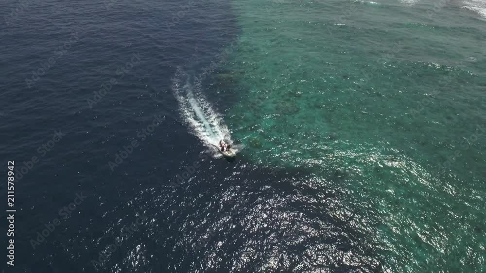 Aerial view of a speedy motorboat with scuba divers, near to coral reef Aerial view of a speedy motorboat with scuba divers, near to coral reef
