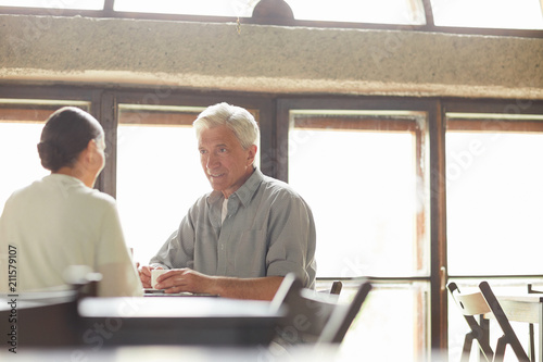 Senior couple having rest and tea in cafeteria in the middle of the day after walk