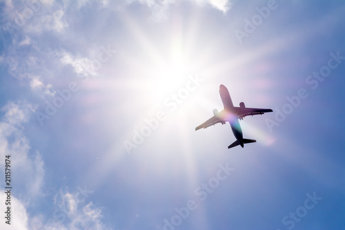 Obraz na płótnie The plane flies in the sky against the sun.