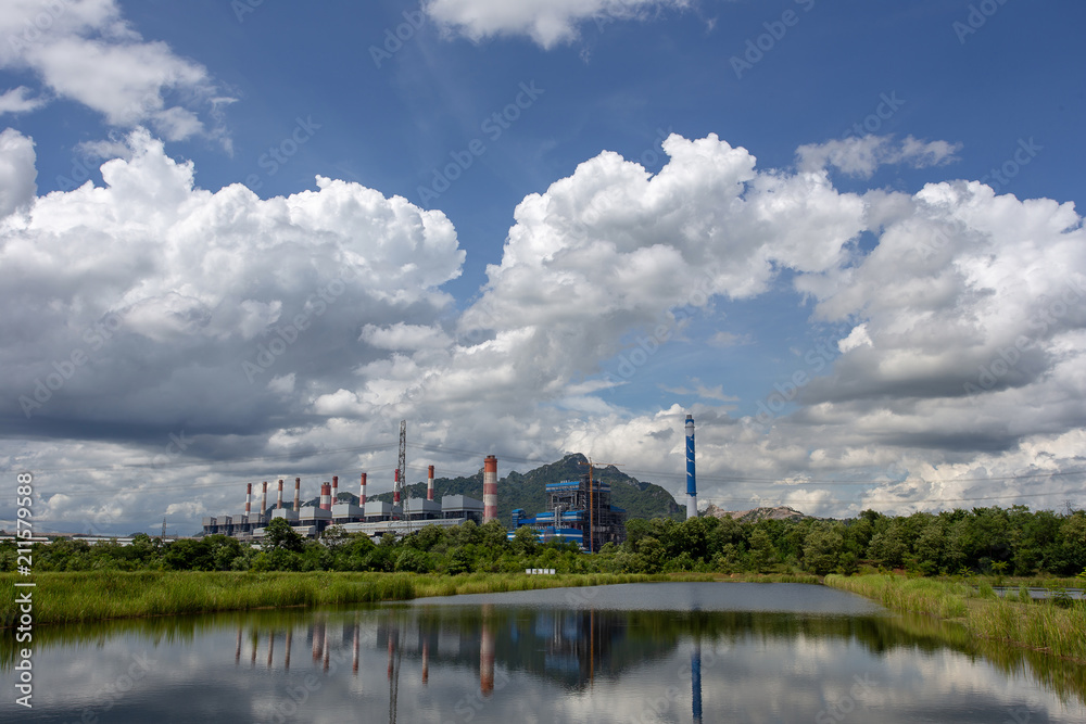 White fluffy clouds in the blue sky and Power plant background