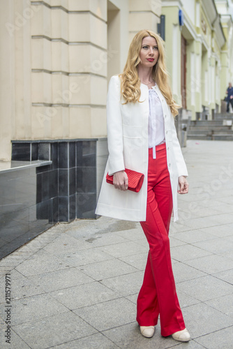 Fashionable young blonde in a spring fashionable suit and with a shopping bag in the center of Moscow
